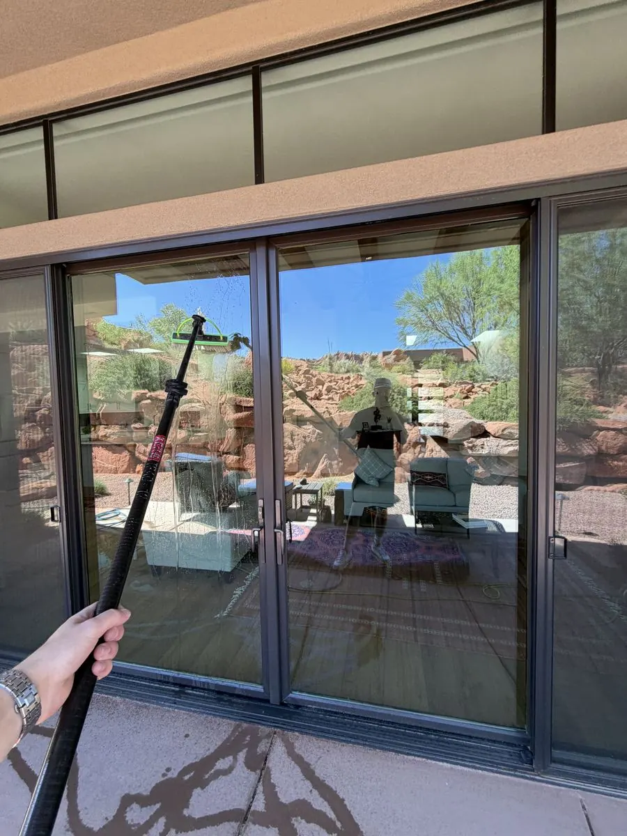 Sliding glass doors cleaned spotless, framing a red rock desert backyard