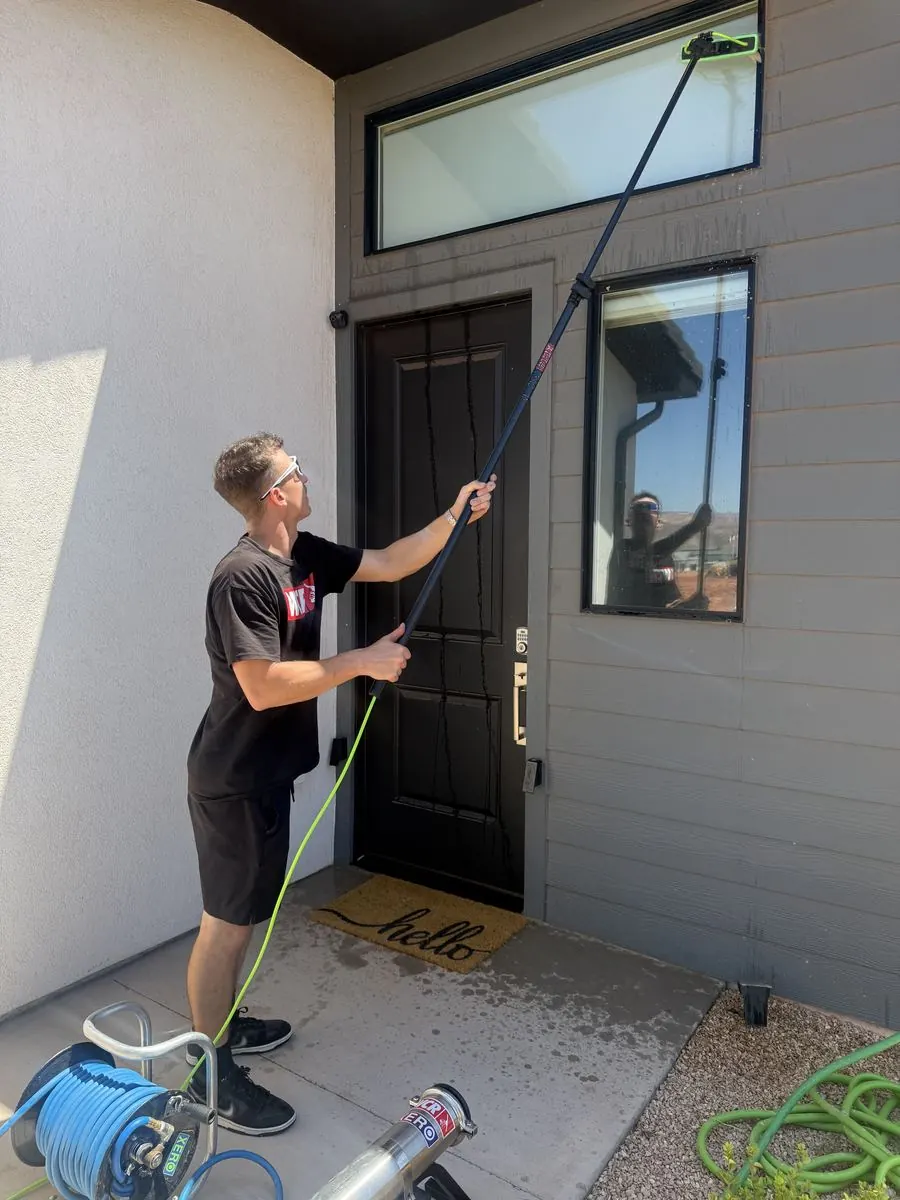 Technician cleaning the entry window above a welcome mat