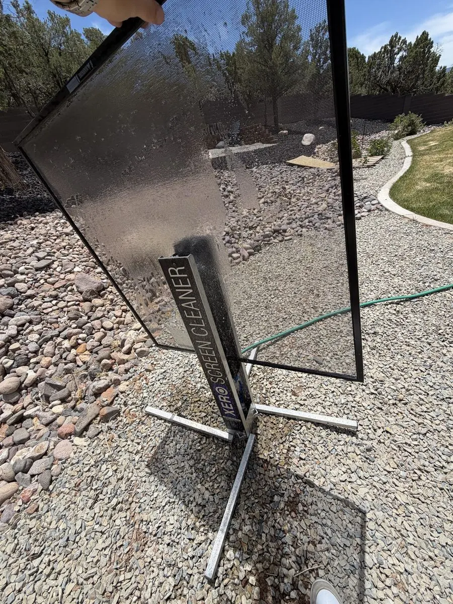 Window screen being cleaned on a screen-cleaning stand