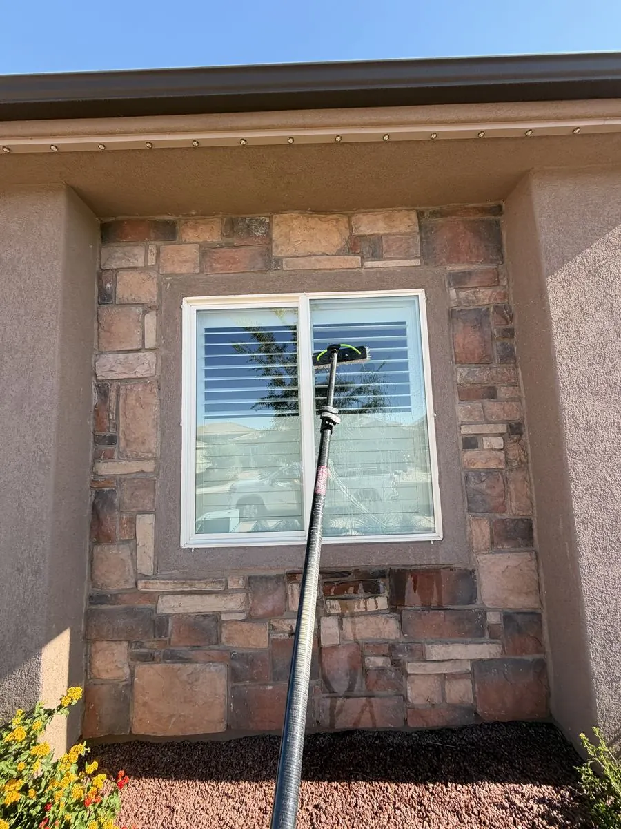 Technician cleaning a window from a rooftop deck