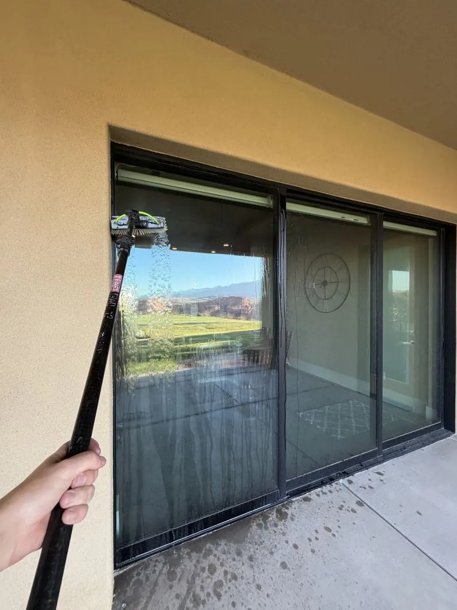 Close-up window cleaning, blinds visible through the glass