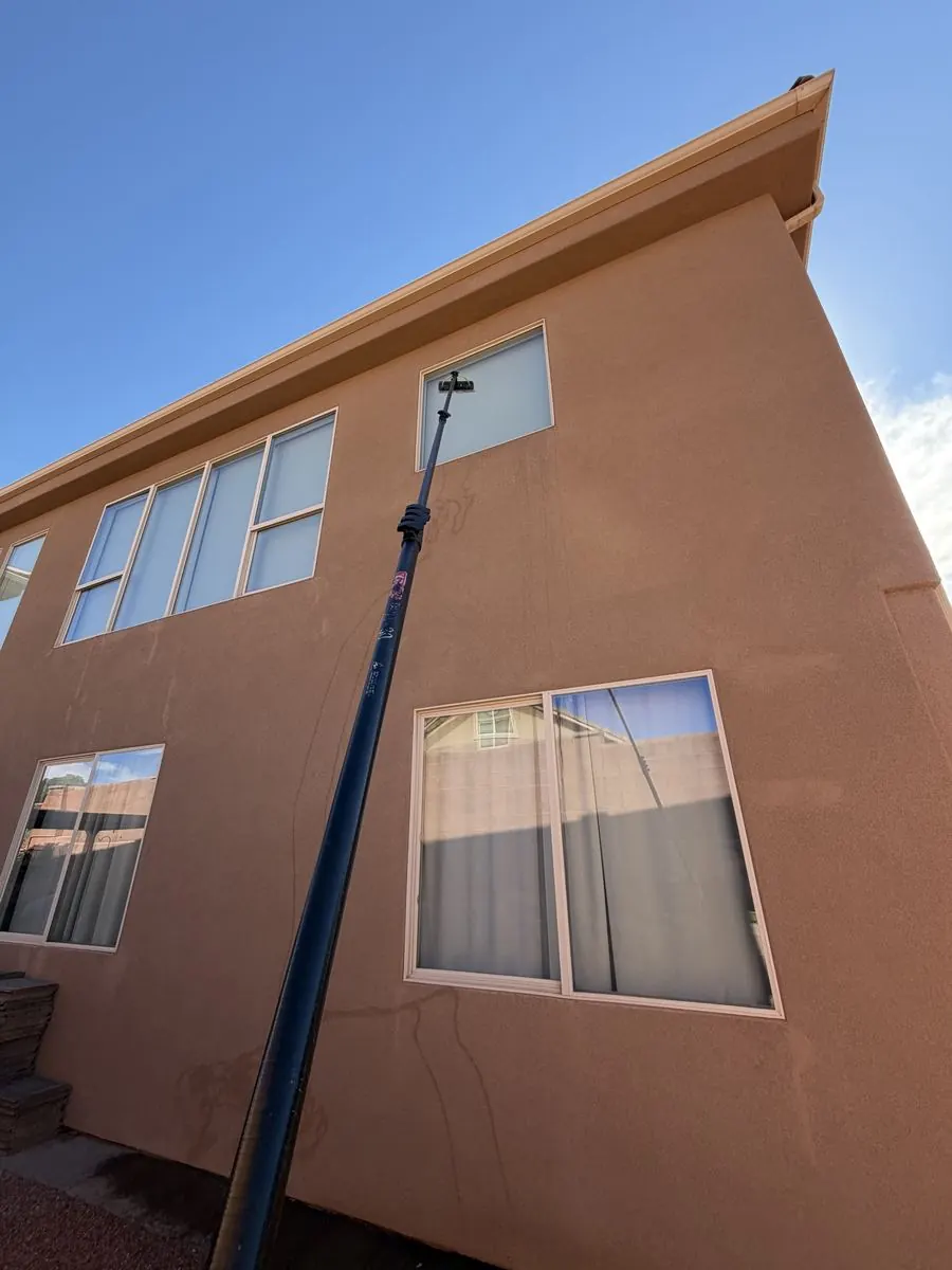 Extension-pole cleaning on a tall stucco building