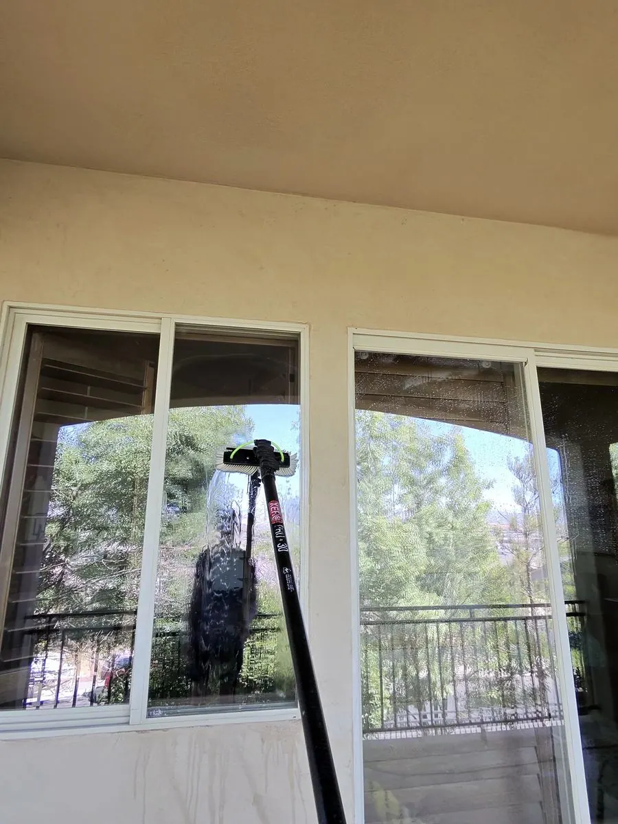 Window cleaned near a patio railing, mountain view