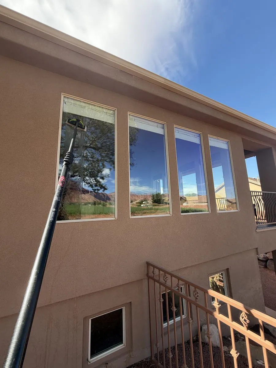 Second-story window cleaned above a stairway railing