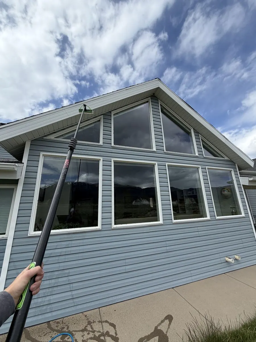 Second-story window cleaned near a gutter downspout